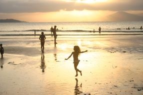 people walking in the sun in shallow sea water
