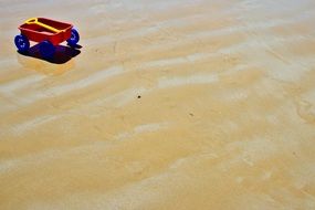 children's toy car on a yellow beach