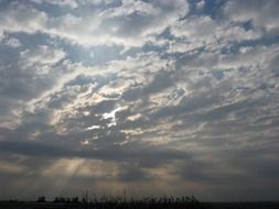 sun behind white clouds