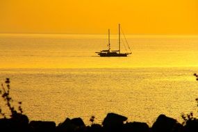 distant view of the boat in the yellow sunset