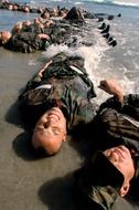 exhausted militarys men in the water by the ocean
