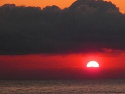 dark clouds in red sunset over the sea