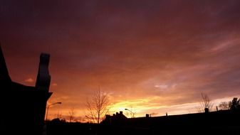 Colorful evening sky above silhouettes of the roofs
