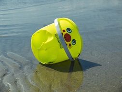 yellow bucket as a beach toy