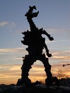 sculpture of the wawel dragon in krakow at dusk