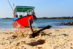 red boat on anchor beach scene