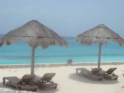 beach beds under parasols in front of ocean, mexico, cancun