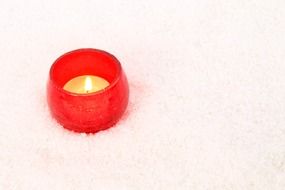 burning candle in red pot closeup