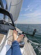 female legs on a sailing boat in the sea