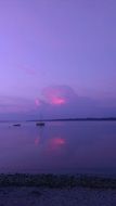 purple and pink sunset mirroring on calm water