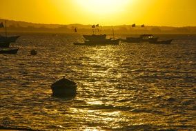 yellow sunset glow over boats on the water, buzios