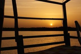 wooden pier against the setting sun