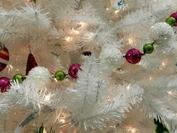 colorful christmas decorations on white christmas tree