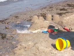 children's toys in the sand on the coast of the Baltic Sea