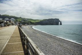 picturesque coastline with stone beach and distant cliff, france, normandy beach coast cliff
