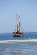 People on the background of a small ship in the Mediterranean