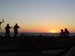 Silhouettes of the people and sunset in the evening