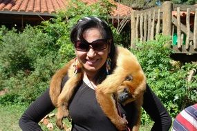 monkey lies on the neck of a woman