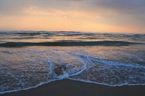 waves on the beach of the north sea during sunset