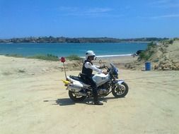 cop on a motorcycle on the beach in Ecuador