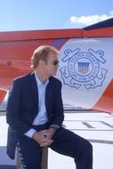 man and coat of arms boat