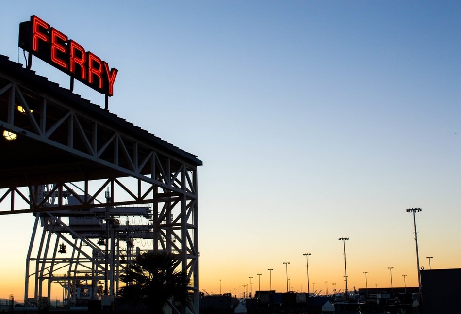 red ferry lettering at top of metal construction at sunset sky