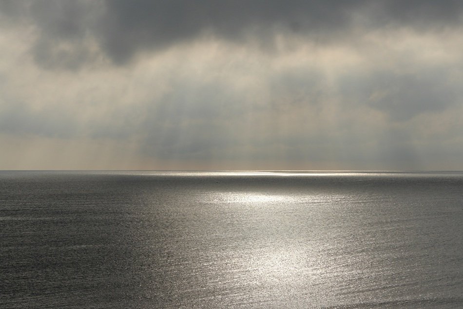 cloud over calm ocean water