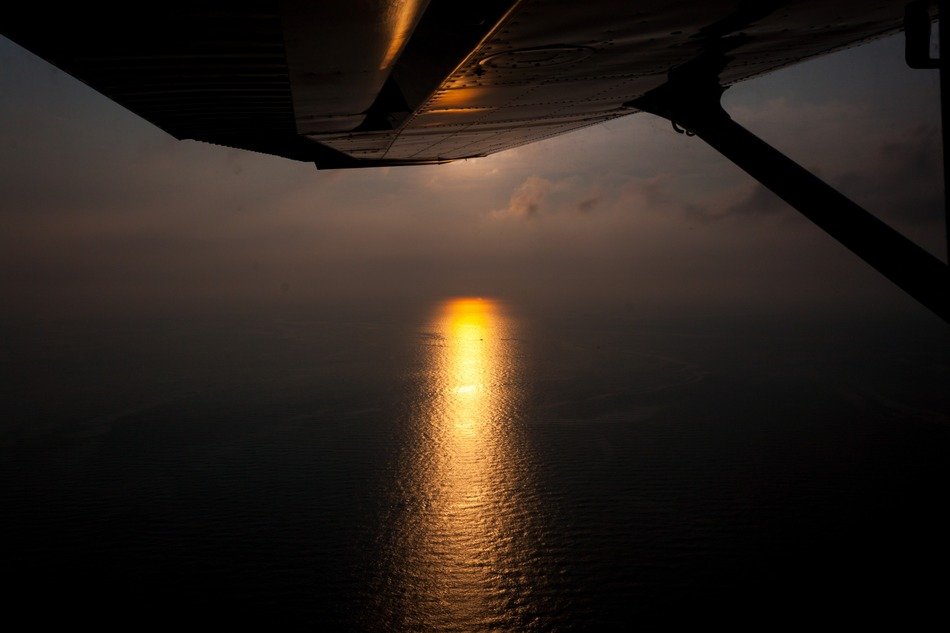 wing of the plane on the background of the trail of the setting sun on the ocean