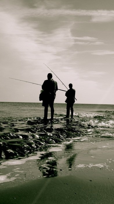 fishermen stand on the beach