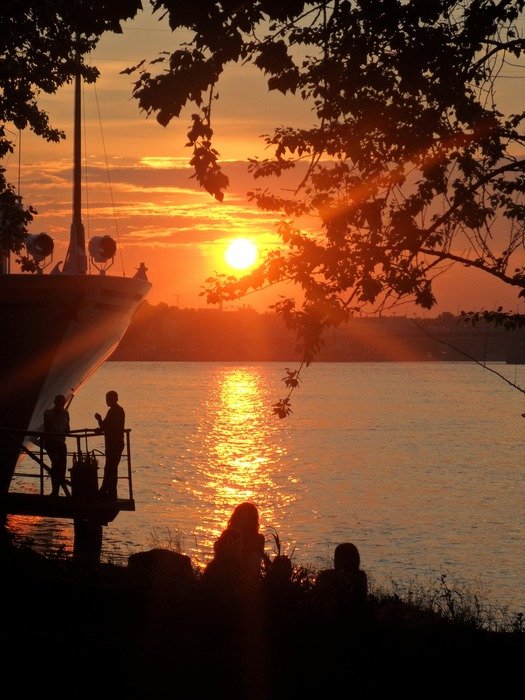 people on the river at sunset