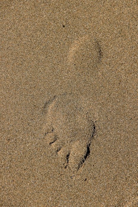track of bare foot on sand