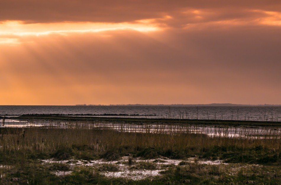 sunset behind the clouds on the north sea