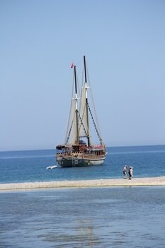 People on the background of a small ship in the Mediterranean