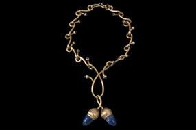 gold pendant with stones in the form of acorns