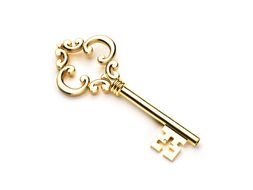 photo of antique golden key on a white table