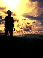 silhouette of a young man on the beach at sunset