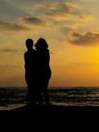 silhouette of couple on the background of the sea at the sunset