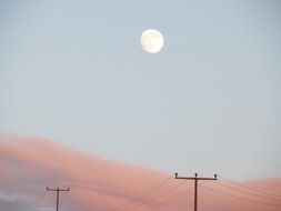 moon in blue sky above sunset afterglow