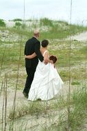 the wedding couple is walking along the coast