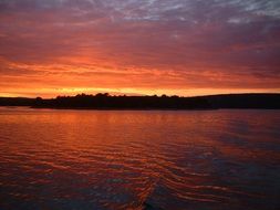 orange clouds reflect on the surface of the water at sunset in Croatia