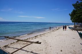 people walk along the ocean coast