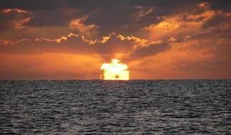giant sun is setting in the sea