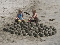 children to stick a tower out of sand on the beach