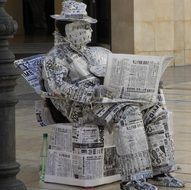 sitting man made entirely of newspaper