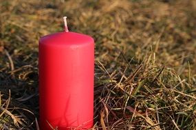 red candle on green grass