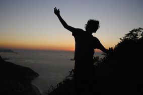 silhouette of a man at sunrise near the ocean