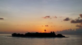 Maldives island at the colorful sunset among the clouds