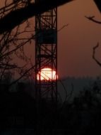 setting sun behind tower crane