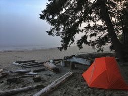 red camping tent near water scene