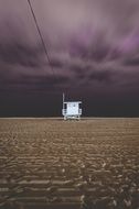 Tower of the lifeguard on the beach under storm clouds